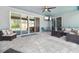 Covered patio with ample seating, ceiling fan, and views of the backyard and pool at 11852 Lake Lucaya Dr, Riverview, FL 33579