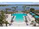 Aerial view of the community pool featuring a large pool, plenty of seating, and beautiful palm trees with lake views at 11852 Lake Lucaya Dr, Riverview, FL 33579