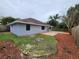 A fully fenced yard with a freshly painted house, a concrete patio, and landscaping with mulch at 12312 Golden Oak Cir, Hudson, FL 34669