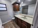 Bathroom featuring vanity with marble countertop, dark wood cabinets, and a large mirror at 12312 Golden Oak Cir, Hudson, FL 34669