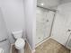 Bathroom featuring a toilet, a modern shower, and a door at 12312 Golden Oak Cir, Hudson, FL 34669