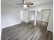 Bedroom featuring wood-look vinyl flooring, mirrored closet doors, and a ceiling fan at 12312 Golden Oak Cir, Hudson, FL 34669