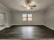 Open living room with wood-look flooring, neutral walls, and natural light from large window at 12312 Golden Oak Cir, Hudson, FL 34669