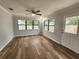 Bright living room with wood-look flooring and large windows for natural light at 12312 Golden Oak Cir, Hudson, FL 34669