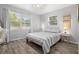 Bright bedroom with two windows, features modern decor and wood-look floors at 1276 Bertland Way, Clearwater, FL 33755