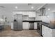 Modern kitchen featuring stainless steel appliances, sleek black countertops, and white cabinets, offering both style and functionality at 1276 Bertland Way, Clearwater, FL 33755
