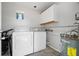 Functional laundry room equipped with a washer, dryer, storage cabinets, and water heater at 1276 Bertland Way, Clearwater, FL 33755