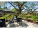 Relaxing outdoor patio space with stylish furniture, complemented by tropical landscaping and a serene backyard setting at 1276 Bertland Way, Clearwater, FL 33755