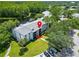 Aerial view of a building with well-maintained landscaping, a parking area, and a view of a pond at 1309 Pine Ridge E Cir # D3, Tarpon Springs, FL 34688