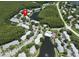 Aerial view of a community featuring residential buildings, a pool, a tennis court, lakes, and green spaces at 1309 Pine Ridge E Cir # D3, Tarpon Springs, FL 34688
