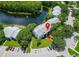 Aerial view of a condo building near a lake, showcasing lush landscaping, parking, and building architecture at 1309 Pine Ridge E Cir # D3, Tarpon Springs, FL 34688