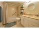 Cozy bathroom with a shower and tub combination, complemented by a neutral color scheme and a round mirror at 1309 Pine Ridge E Cir # D3, Tarpon Springs, FL 34688