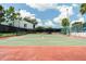 Tennis court in a beautiful community with green and red surface, surrounded by lush greenery at 1309 Pine Ridge E Cir # D3, Tarpon Springs, FL 34688