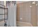 Tiled bathroom space including a shower/tub combo with decorative floral shower curtain and shelving at 13421 Sydney Rd, Valrico, FL 33594