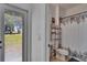 Bright bathroom featuring a toilet, sink, shelving, and a shower with a decorative floral curtain at 13421 Sydney Rd, Valrico, FL 33594