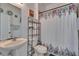 Bathroom includes a sleek pedestal sink, decorative floral shower curtain, and modern shelving at 13421 Sydney Rd, Valrico, FL 33594
