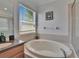 A bright bathroom featuring a large, inviting soaking tub with a clean, tiled surround at 13421 Sydney Rd, Valrico, FL 33594