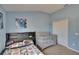 Bedroom with blue walls features a window, a twin bed, a crib, and a closet at 13421 Sydney Rd, Valrico, FL 33594