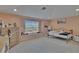 Bright bedroom with large window, peach walls, and comfortable furnishings at 13421 Sydney Rd, Valrico, FL 33594