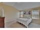 Bright bedroom featuring a bed with neutral bedding, complemented by natural light from two windows at 13421 Sydney Rd, Valrico, FL 33594