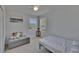 Bright bedroom with a full sized bed and a seating area with soft natural lighting from two windows at 13421 Sydney Rd, Valrico, FL 33594
