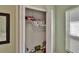 A walk-in closet with white shelving, clothes hanging, and toys, next to a sunlit window at 13421 Sydney Rd, Valrico, FL 33594