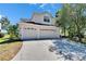 Charming two-story home with a spacious driveway and a three-car garage, landscaped for curb appeal under a bright blue sky at 13421 Sydney Rd, Valrico, FL 33594