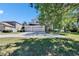 Exterior of home featuring a three-car garage, wide driveway, and a landscaped yard at 13421 Sydney Rd, Valrico, FL 33594