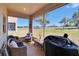 Relaxing screened porch featuring comfortable seating and a peaceful view of the community green space at 13421 Sydney Rd, Valrico, FL 33594