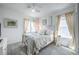 Bright, airy bedroom with a metal bed frame, soft linens, and two windows at 14146 Samoa Hill Ct, Riverview, FL 33569
