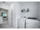 Clean and well-lit laundry room featuring modern, white front-load washer and dryer at 14146 Samoa Hill Ct, Riverview, FL 33569