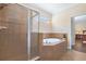 This bathroom features a tiled walk-in shower and a luxurious tub for relaxation at 15608 Starling Water Dr, Lithia, FL 33547
