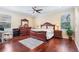 Bedroom featuring a ceiling fan, hardwood floors, large dresser, and windows for natural light at 15608 Starling Water Dr, Lithia, FL 33547