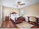 This bedroom features a ceiling fan, hardwood floors, and a desk with chair at 15608 Starling Water Dr, Lithia, FL 33547
