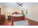 Bright bedroom with natural light, ceiling fan, hardwood floors, and a large dresser with mirror at 15608 Starling Water Dr, Lithia, FL 33547
