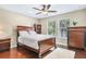 Cozy bedroom with hardwood floors, a ceiling fan, and a large bed to ensure comfort at 15608 Starling Water Dr, Lithia, FL 33547