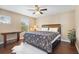 Cozy bedroom with a ceiling fan, a patterned bedspread, and natural light from the window at 15608 Starling Water Dr, Lithia, FL 33547