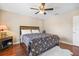 This bedroom features a ceiling fan, a patterned bedspread, and hardwood floors at 15608 Starling Water Dr, Lithia, FL 33547