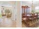 View of dining room adjacent to living room with dark wood table and china cabinet, and arched entrances at 15608 Starling Water Dr, Lithia, FL 33547