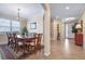 Formal dining room with elegant dark wood table set and an arched entry leading to the main entrance at 15608 Starling Water Dr, Lithia, FL 33547
