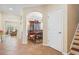 Hallway featuring arched doorways leading to the living room and dining room, with tile flooring and a staircase at 15608 Starling Water Dr, Lithia, FL 33547