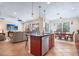 Open concept kitchen with island seating, dark wood cabinets, and stainless steel appliances, adjacent to living area at 15608 Starling Water Dr, Lithia, FL 33547