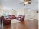 Living room featuring matching leather recliners, hardwood floors, and natural light at 15608 Starling Water Dr, Lithia, FL 33547