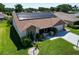 Aerial view of a well-maintained house with solar panels, landscaped yard, and an attached garage at 1575 Wicklow Dr, Palm Harbor, FL 34684
