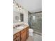 Bathroom featuring a vanity with granite counters, a framed mirror and a glass enclosed shower at 1575 Wicklow Dr, Palm Harbor, FL 34684