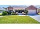 Charming single-story home with a well-maintained lawn, stone accents, and an attached garage at 1575 Wicklow Dr, Palm Harbor, FL 34684