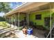 Exterior shot of patio with green siding, a grill, and wood storage next to a vast, green backyard at 16044 Stur St, Brooksville, FL 34604