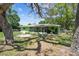 The back of the home showing a large patio area and a grassy backyard with mature shade trees at 16044 Stur St, Brooksville, FL 34604