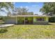 Charming single-story home with a colorful green exterior, stone accents and a welcoming front porch with rocking chairs at 16044 Stur St, Brooksville, FL 34604