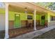 Inviting front porch with rocking chairs and a decorative wreath on the door, complemented by the colorful exterior at 16044 Stur St, Brooksville, FL 34604